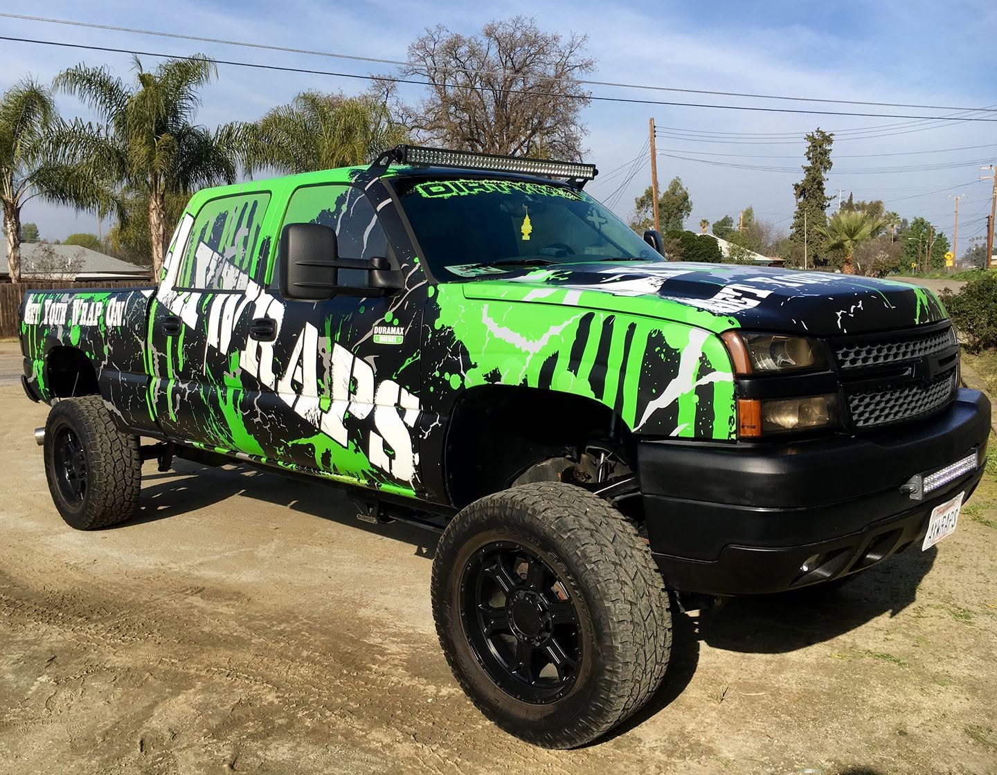 Lifted truck in a custom green-and-black AXWRAPS vehicle wrap